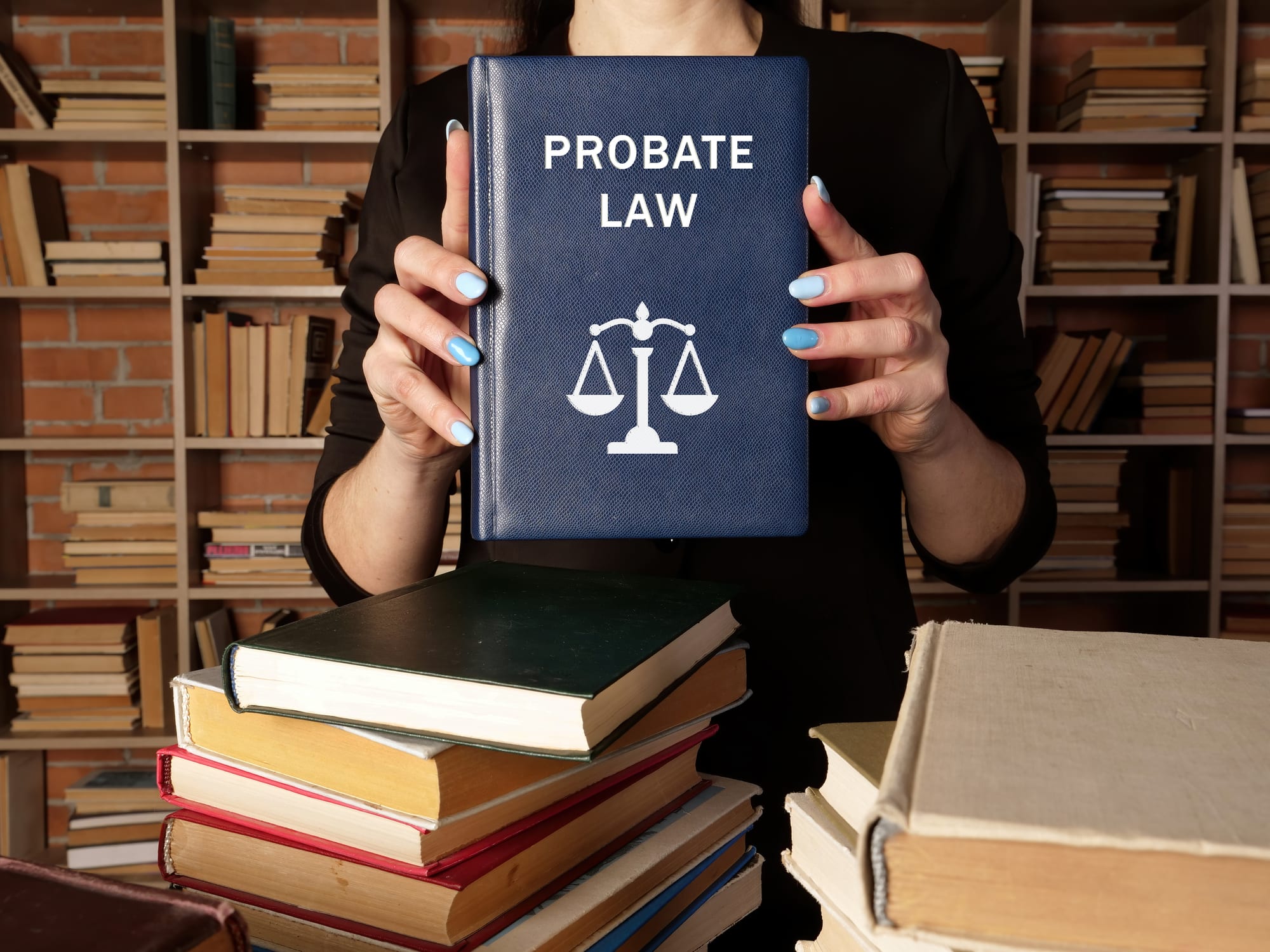 Woman with blue nails holding a book about probate law